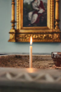 A peaceful scene of a candle burning near a book on spiritual teachings and righteousness.