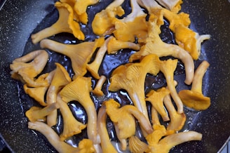 a frying pan filled with lots of yellow mushrooms