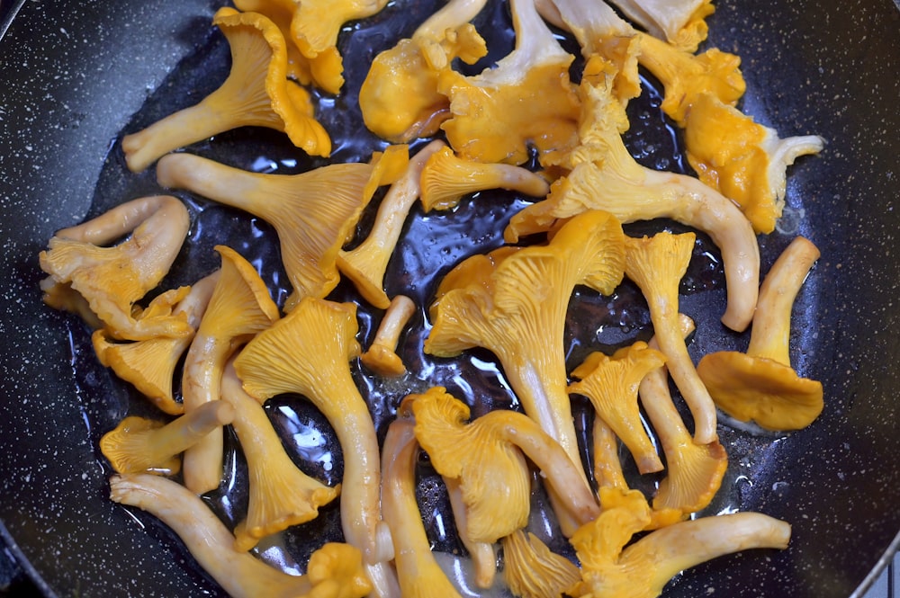 a frying pan filled with lots of yellow mushrooms
