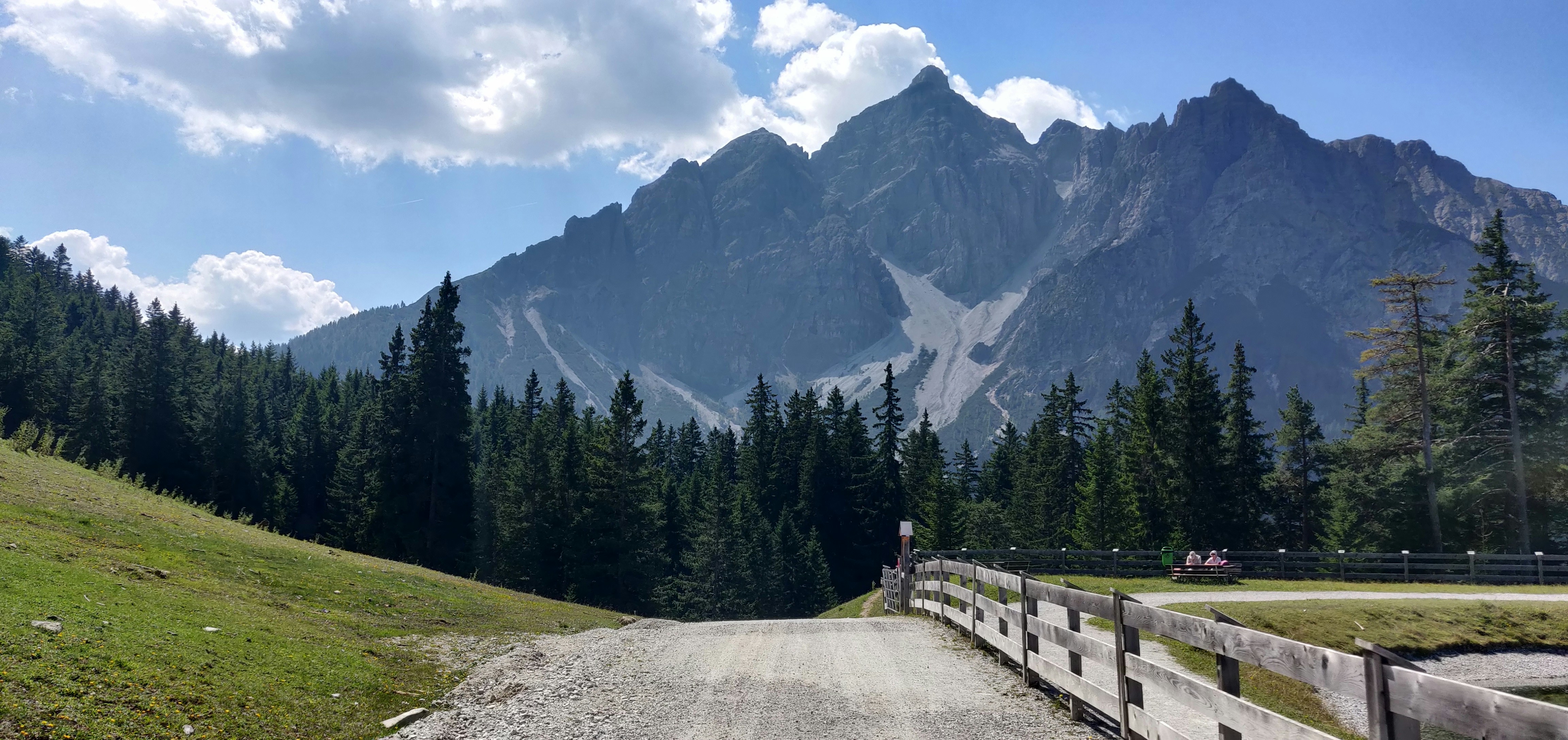 a dirt road in front of a mountain range