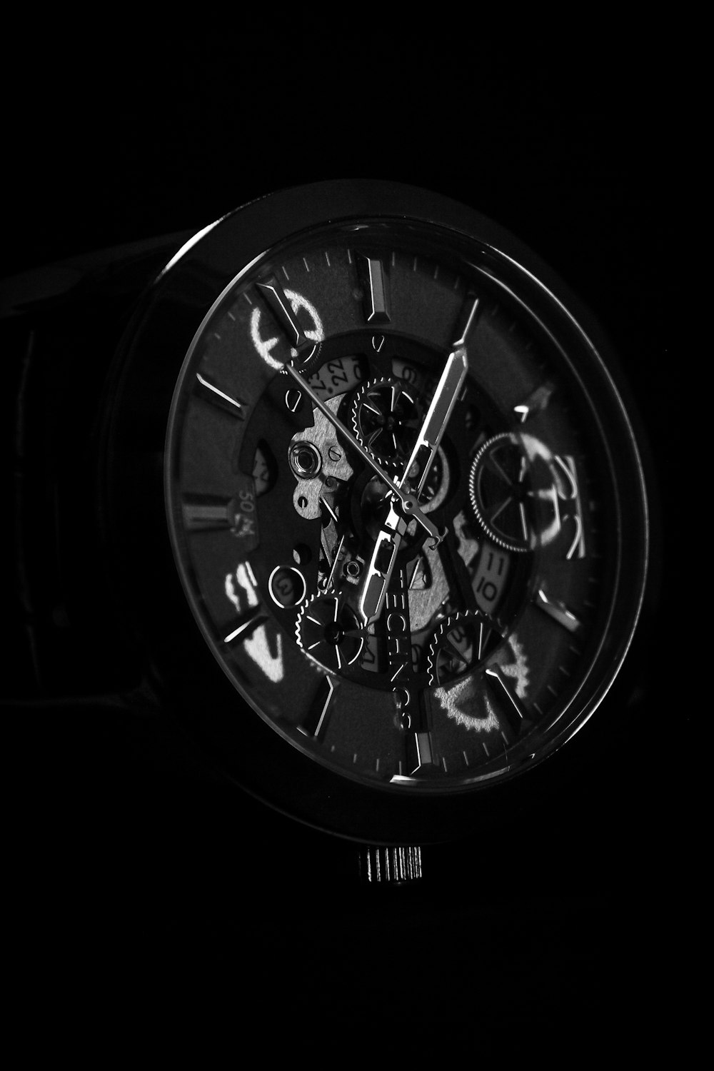 a black and white photo of a watch in the dark