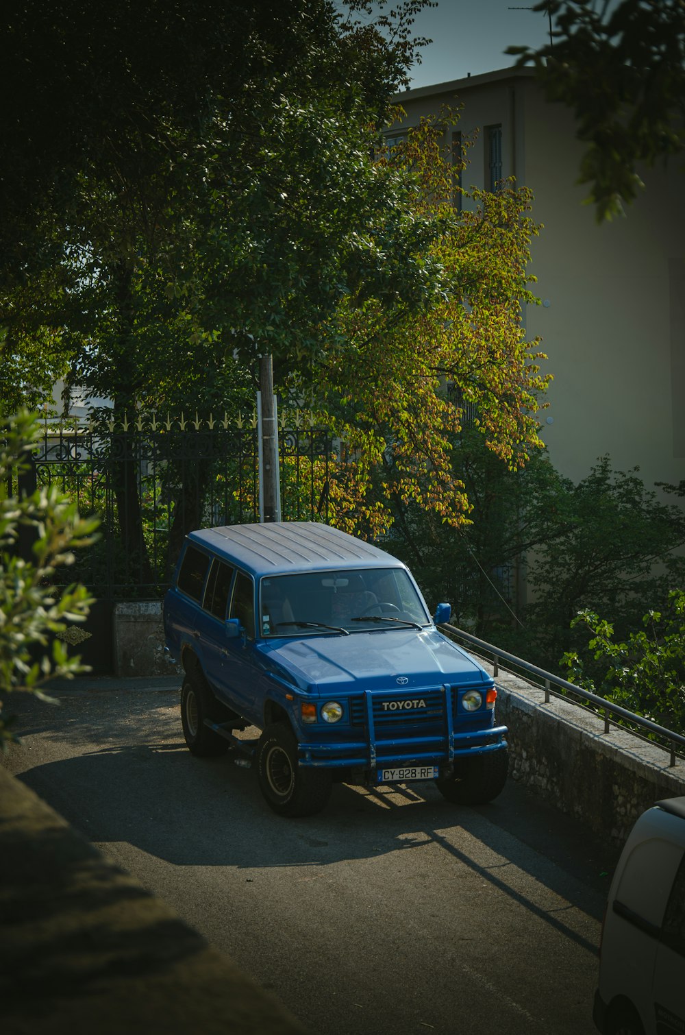 a blue jeep parked on the side of a road