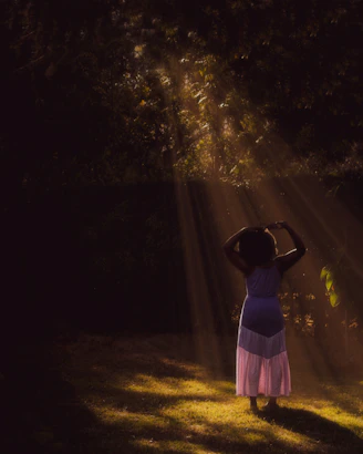 Bright and airy photo of a person wearing a light flowy dress standing in a sunlit urban street