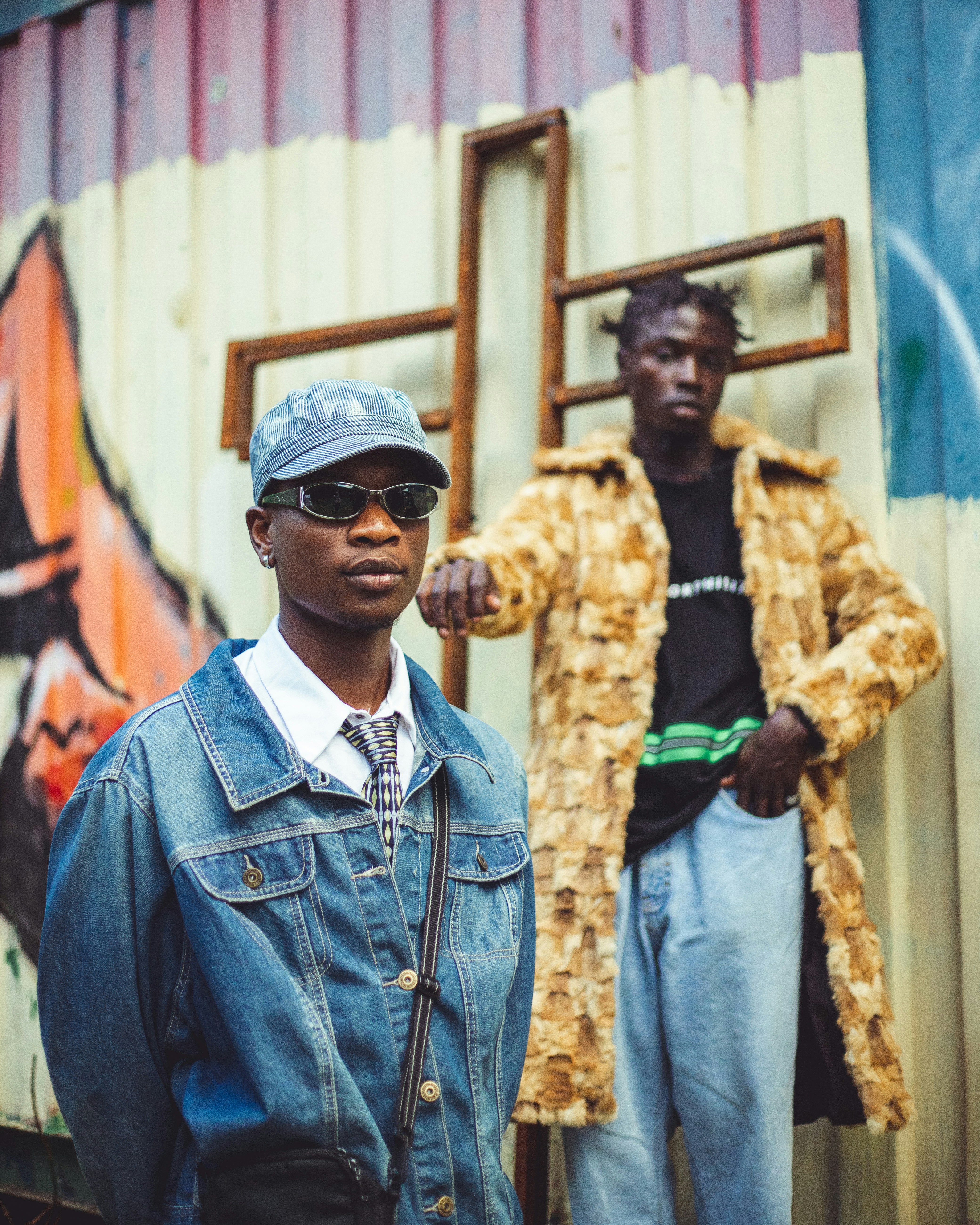 Two men standing next to each other in front of a building photo
