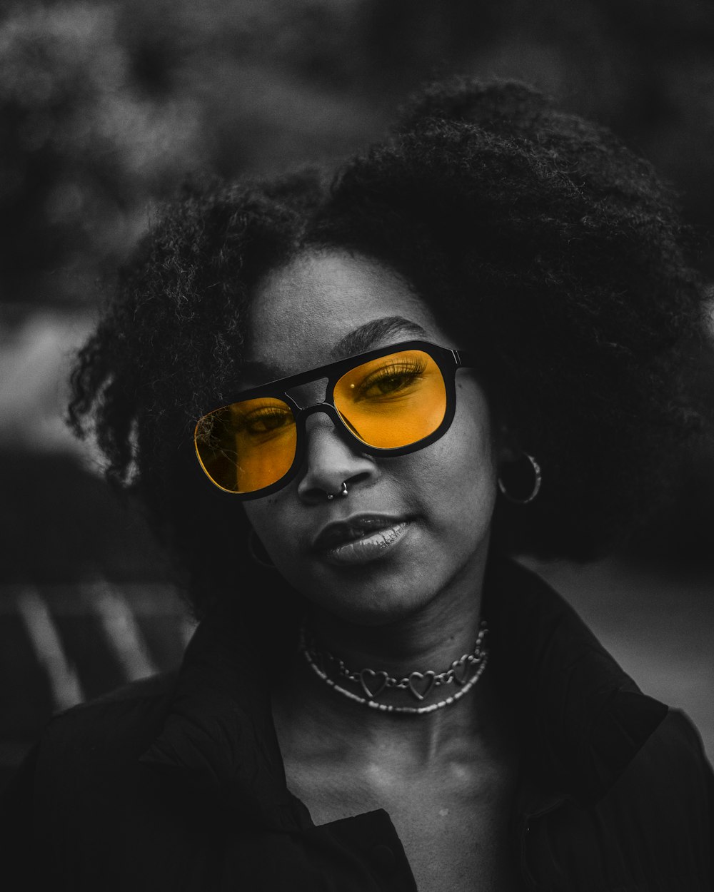 a woman wearing yellow glasses and a chain around her neck