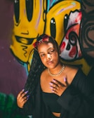 Bigg Britt posing confidently against a graffiti wall with vibrant neon accents.