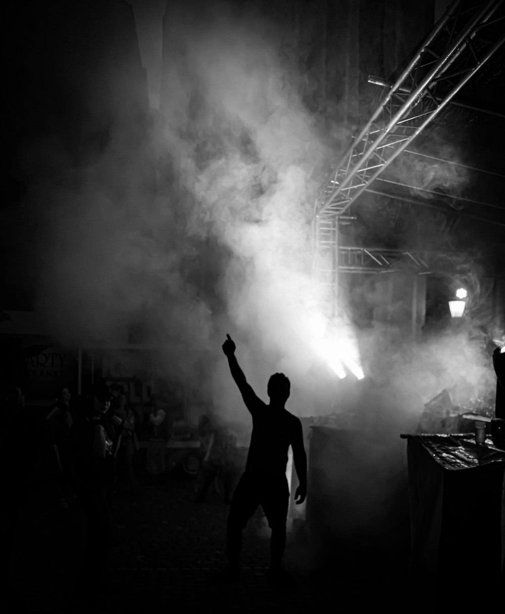 a man standing in front of a stage with smoke coming out of it