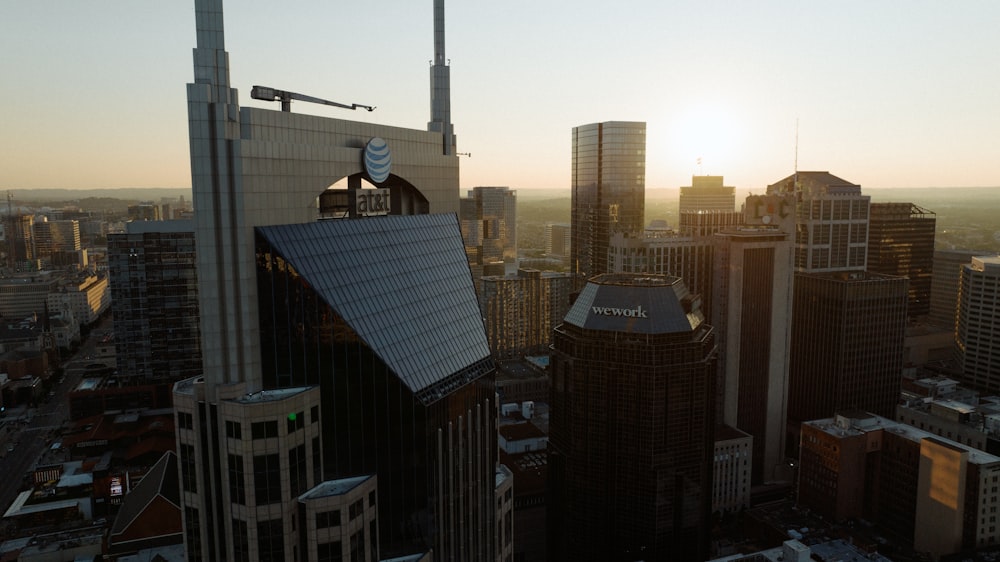 the sun is setting over a city with tall buildings