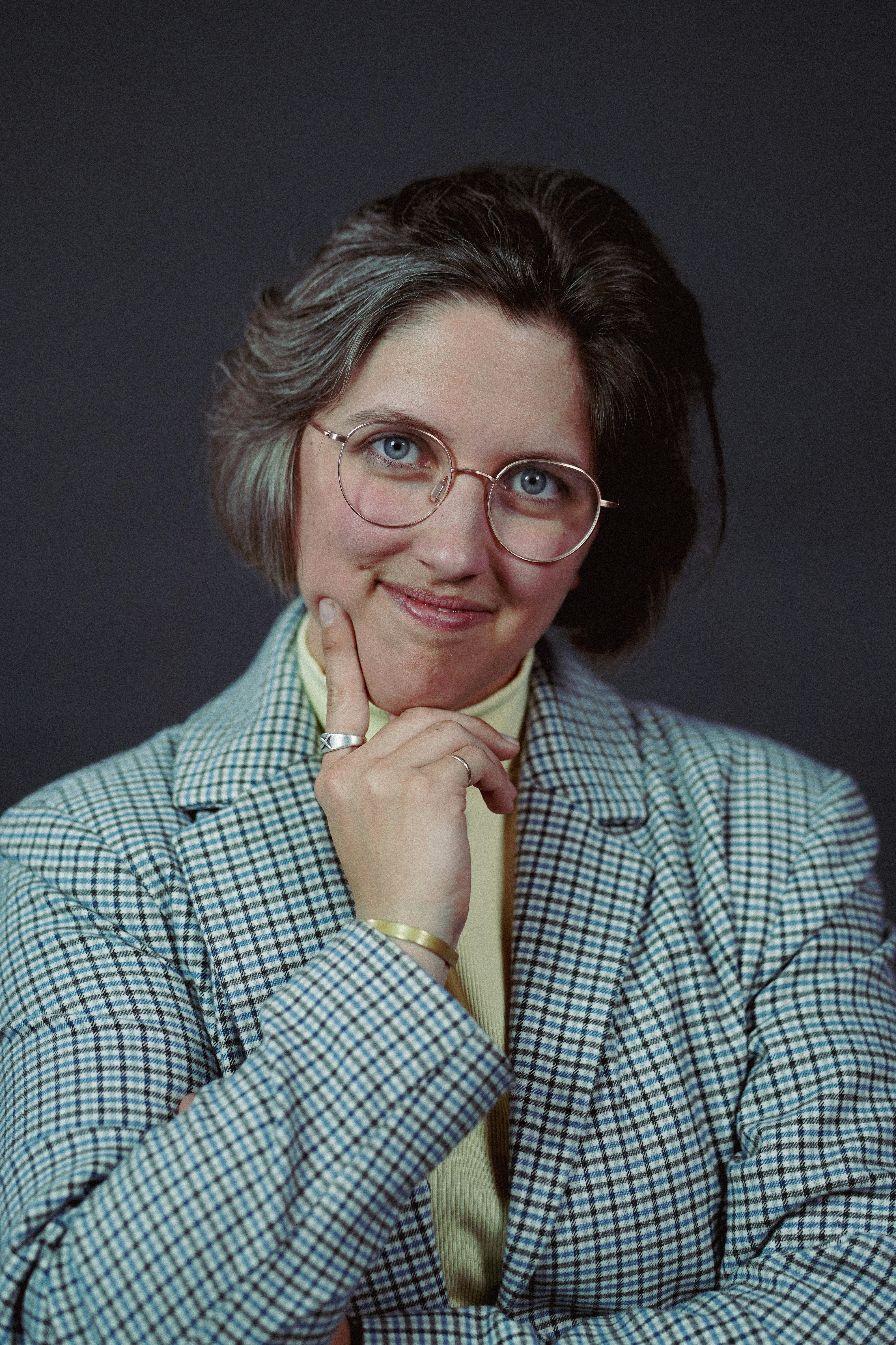 a woman in a suit and glasses posing for a picture