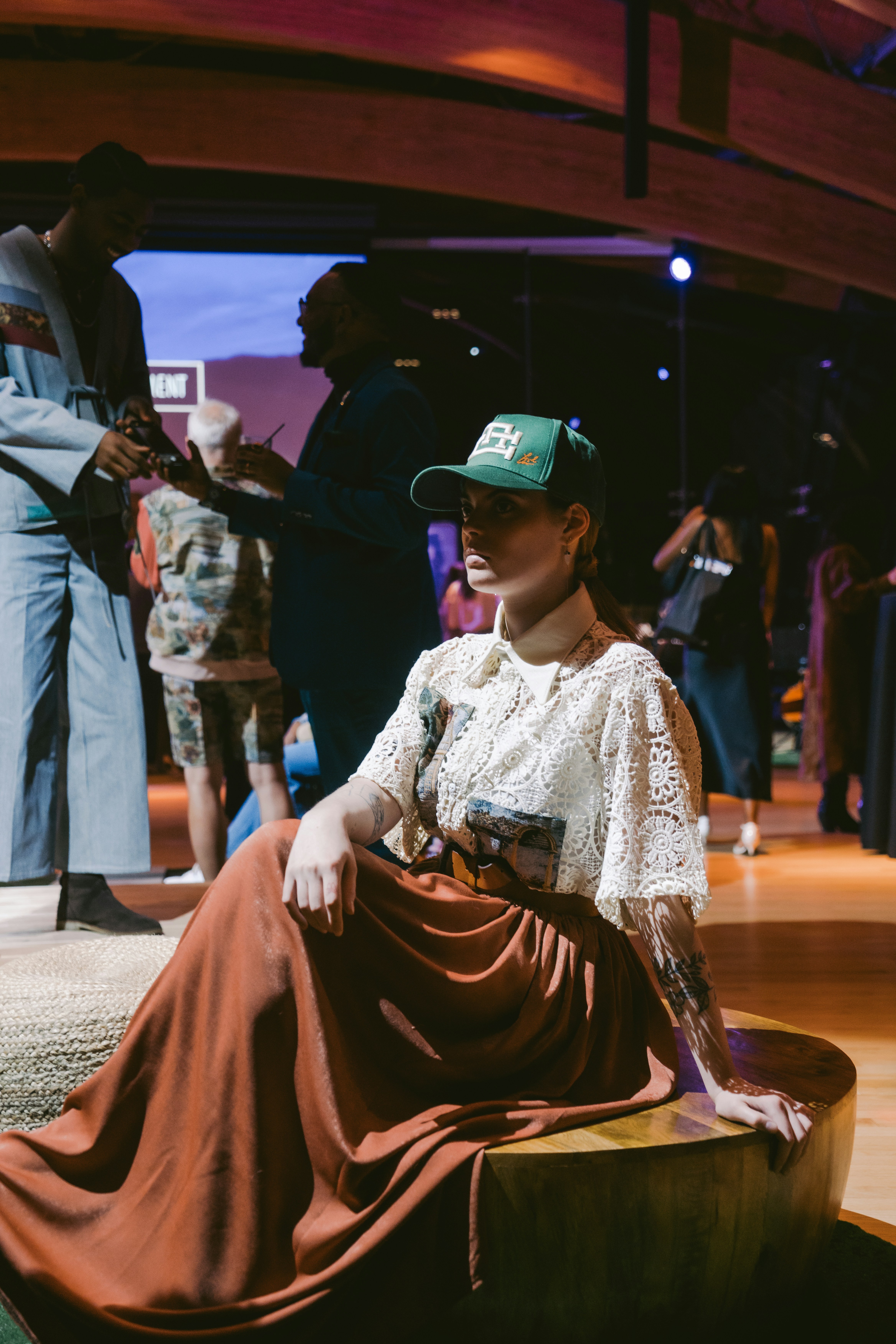 a woman sitting on a bench wearing a hat