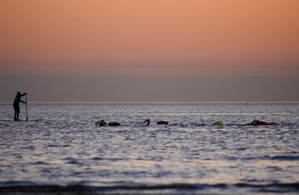 a man standing on a surfboard in the middle of the ocean