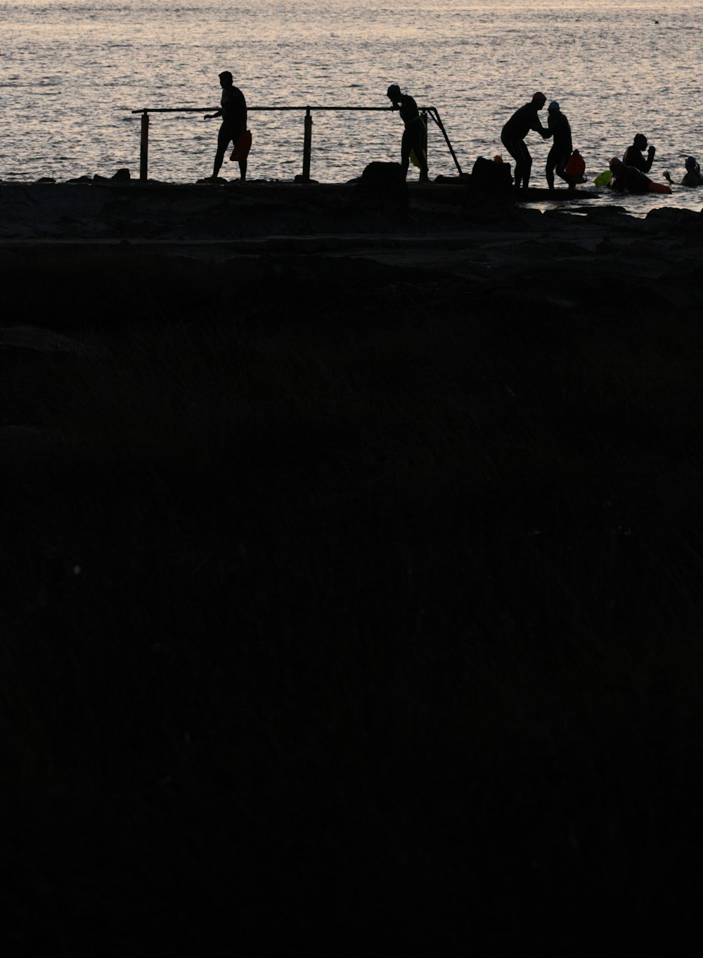 a group of people standing next to a body of water