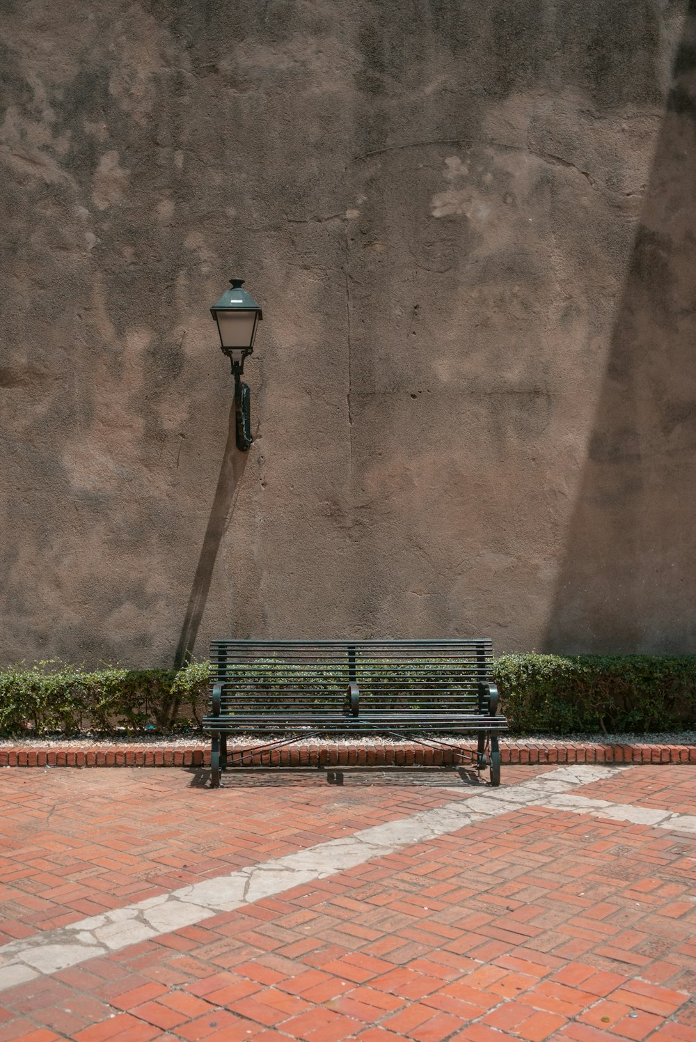 a bench sitting in front of a stone wall