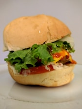 Close-up of a juicy kebab sandwich with fresh vegetables and sauce dripping.