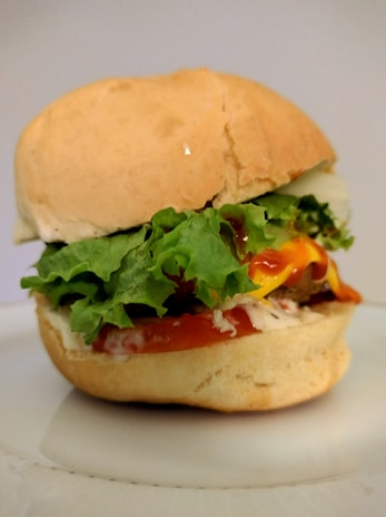 A close-up of a sloppy joe sandwich dripping with savory sauce on a soft bun.