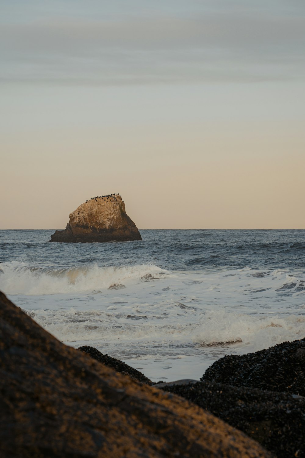 a large rock in the middle of the ocean