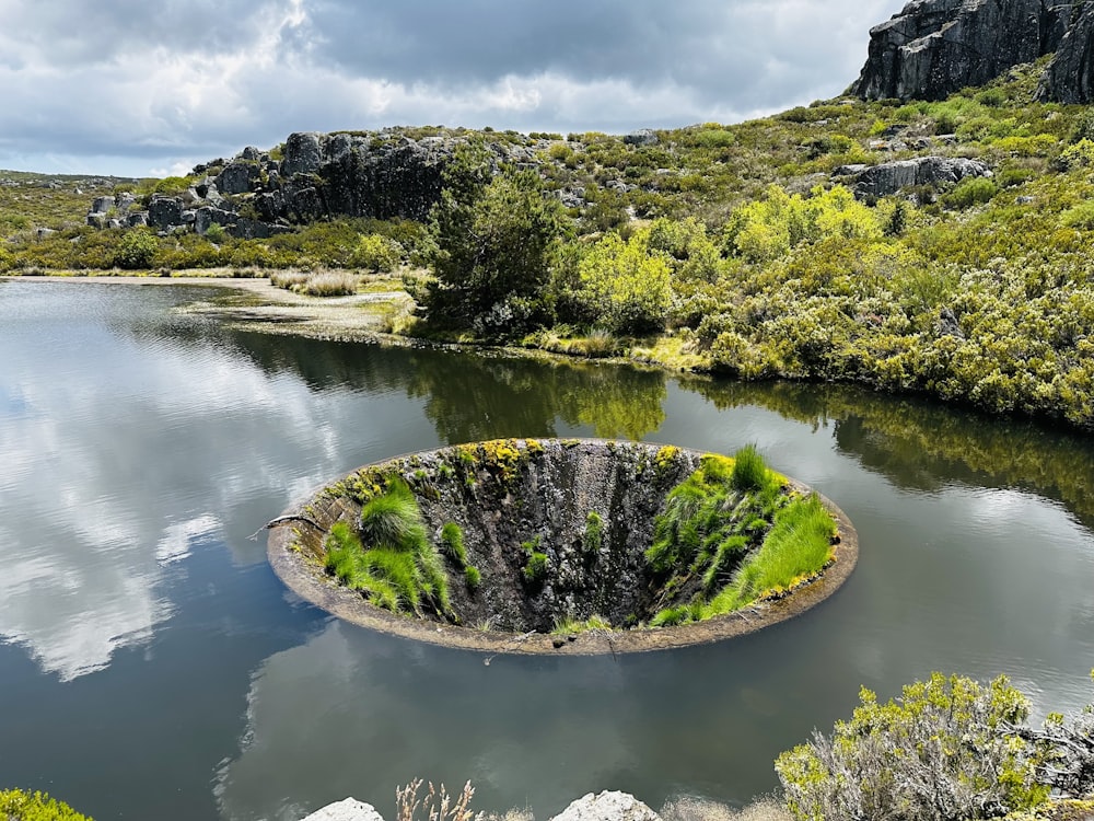 a large body of water surrounded by a lush green hillside