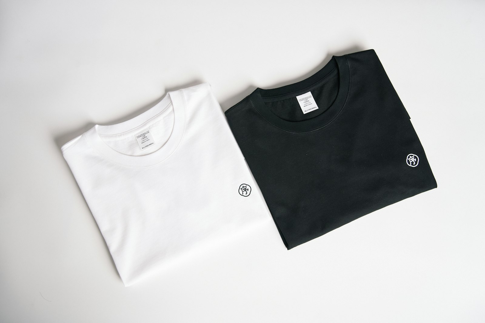 A white T-shirt and a black T-shirt folded side by side