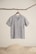 A clean, minimalist shot of a silk shirt hanging gracefully on a wooden hanger.