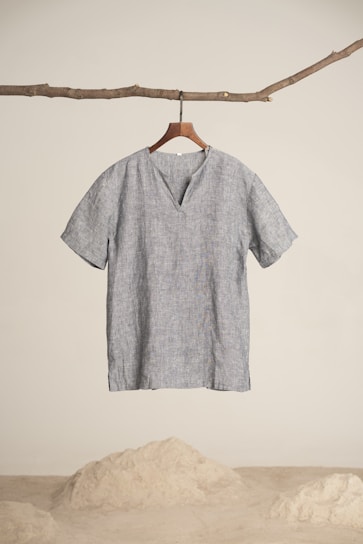 A sleek, minimalistic men's shirt displayed on a wooden hanger against a neutral background