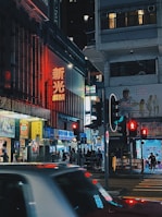 A bustling city street at night, illuminated by colorful neon signs and busy pedestrians.