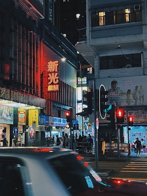 A bustling city street lit up at night with vibrant neon signs.