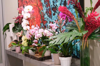 Colorful custom table arrangements featuring handcrafted pots and lush plants.