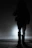 A silhouette of a gothic model standing against a foggy, moonlit backdrop.