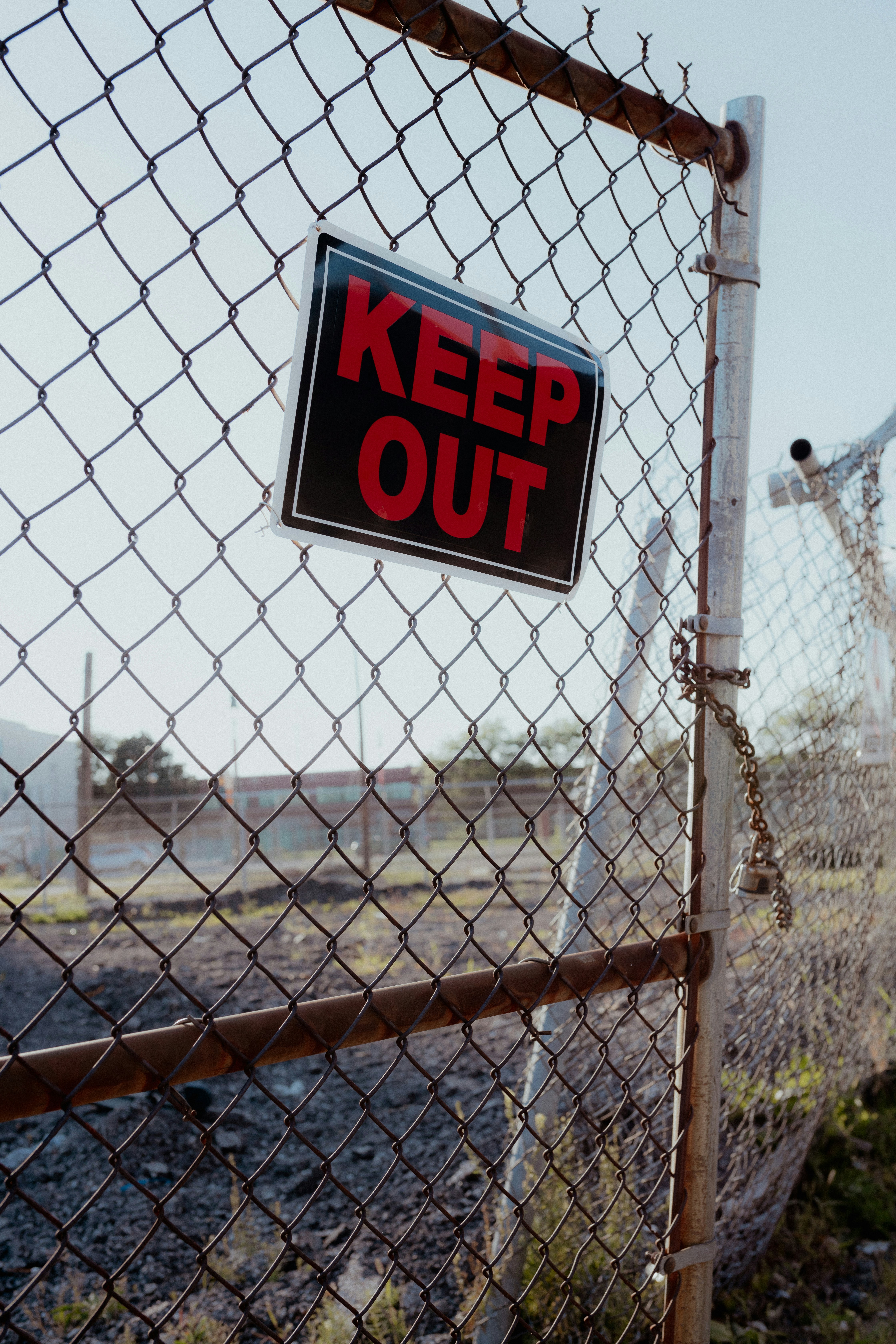 a keep out sign on a chain link fence