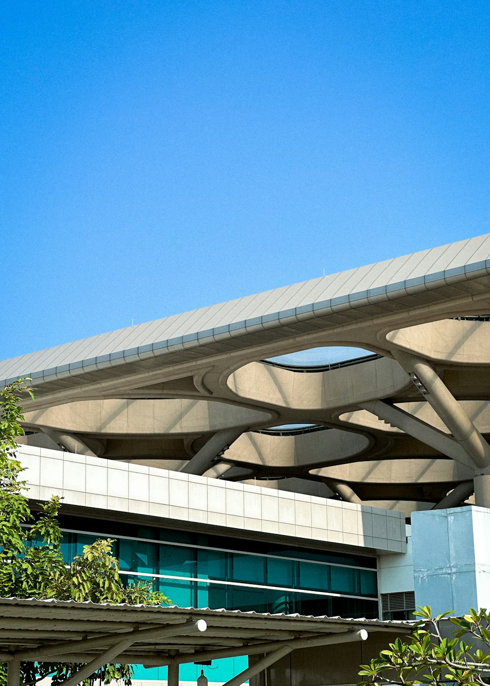 an airplane flying over a building under a blue sky