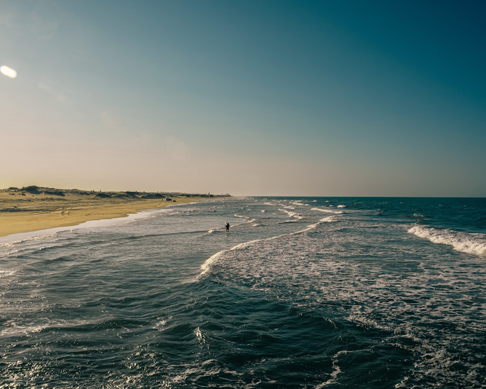 a person is standing in the water at the beach