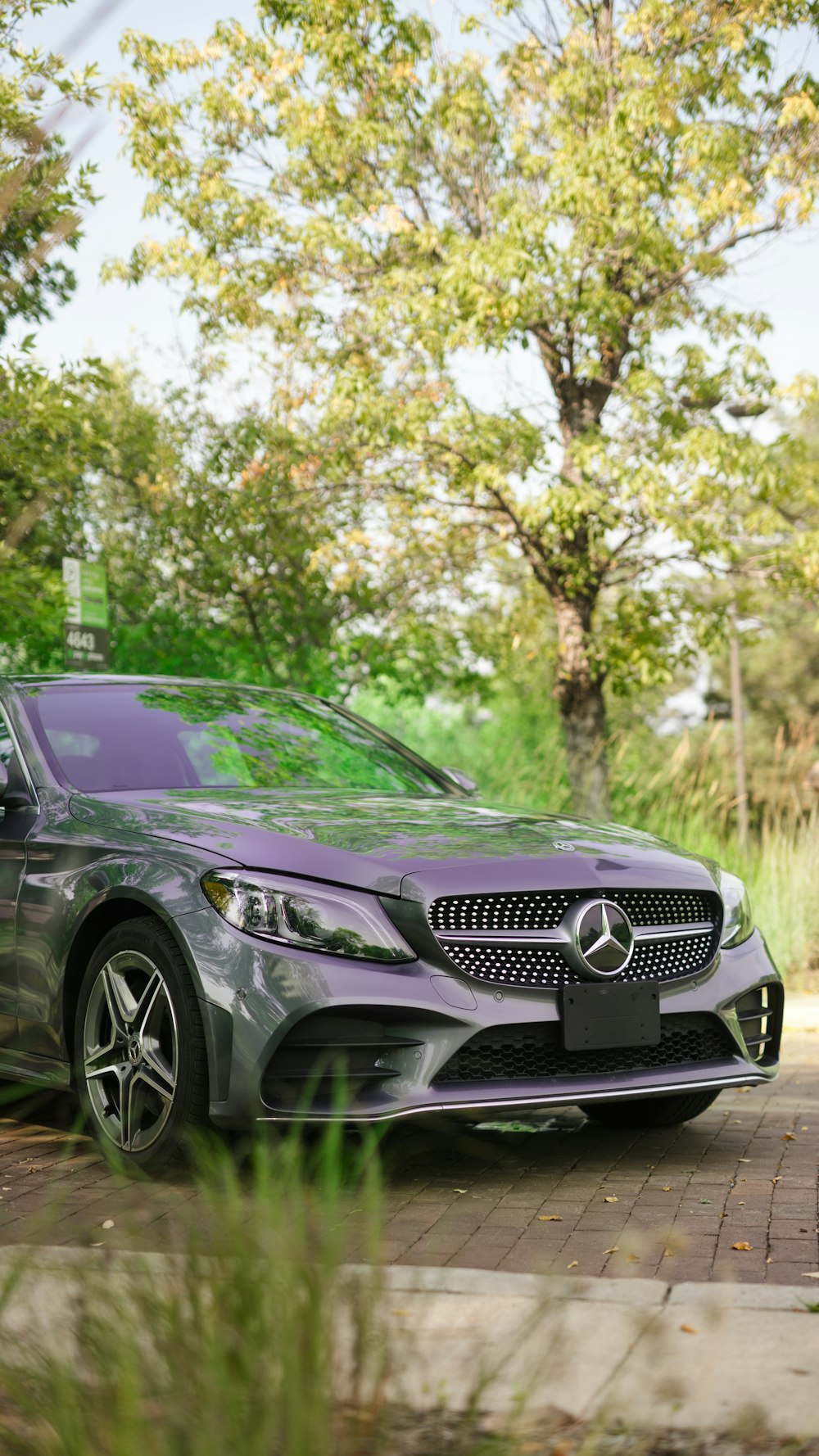 a grey mercedes benz coupe parked on a brick road