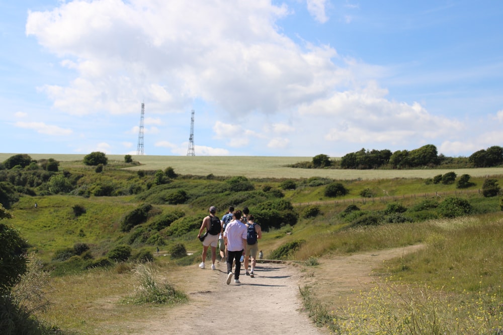 a group of people walking down a dirt road