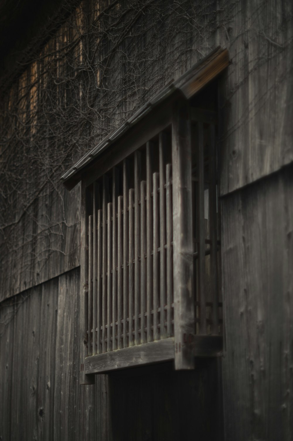 un antiguo edificio de madera con una ventana enrejada