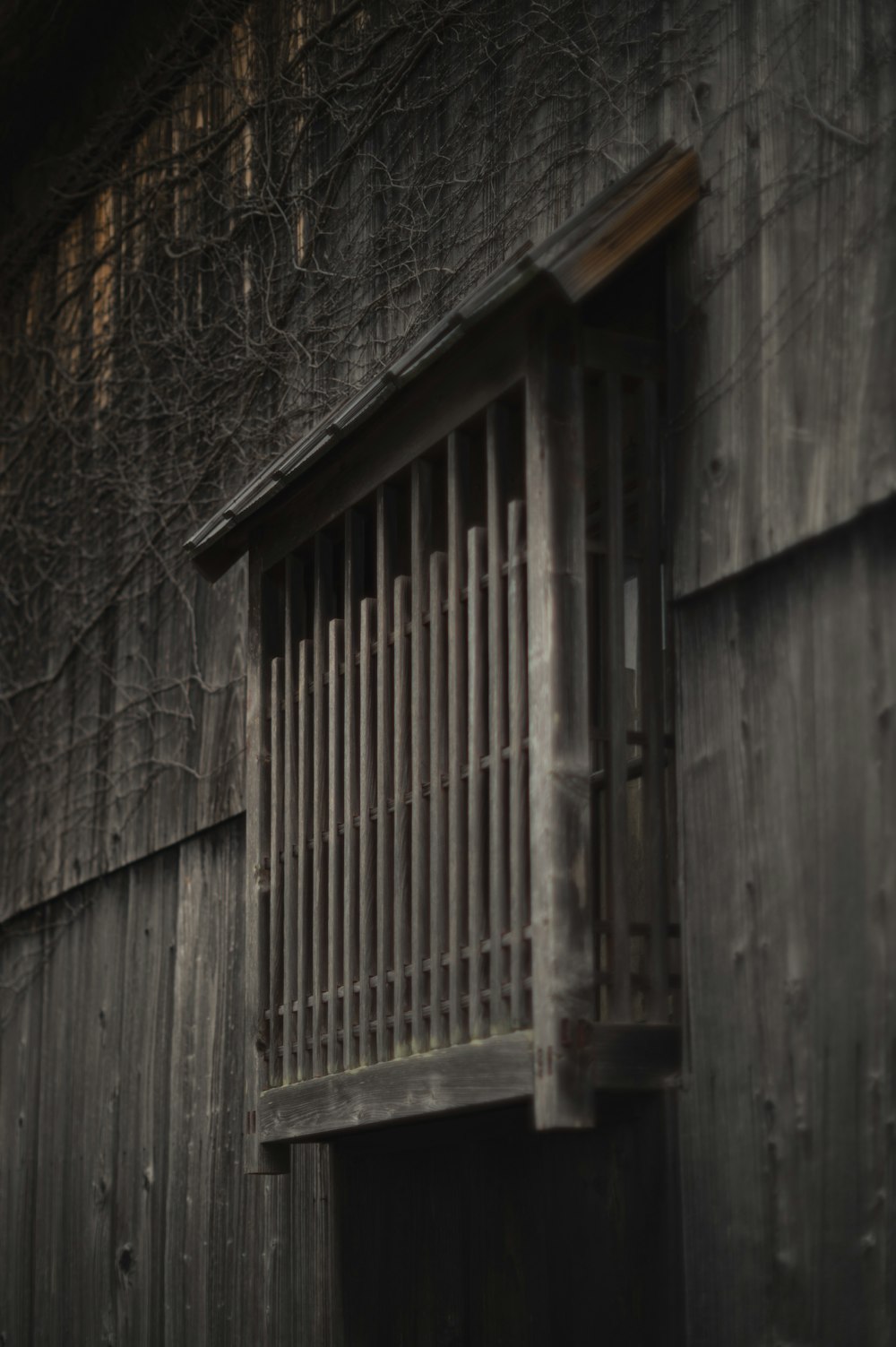 an old wooden building with a barred window