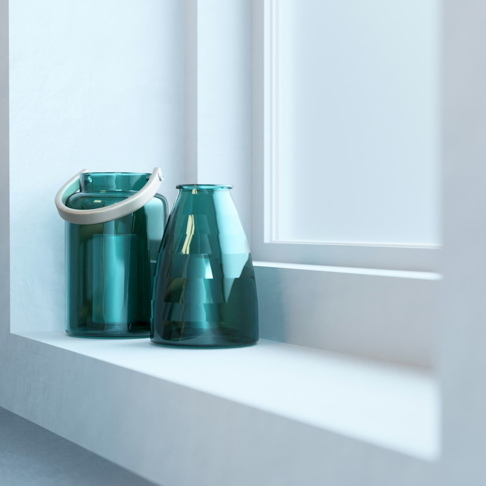 a couple of green vases sitting on top of a window sill