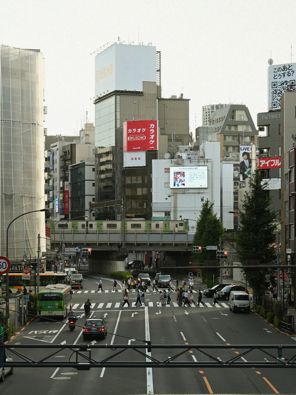 a city street filled with lots of traffic next to tall buildings