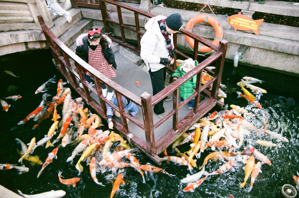 um grupo de pessoas em cima de uma ponte de madeira