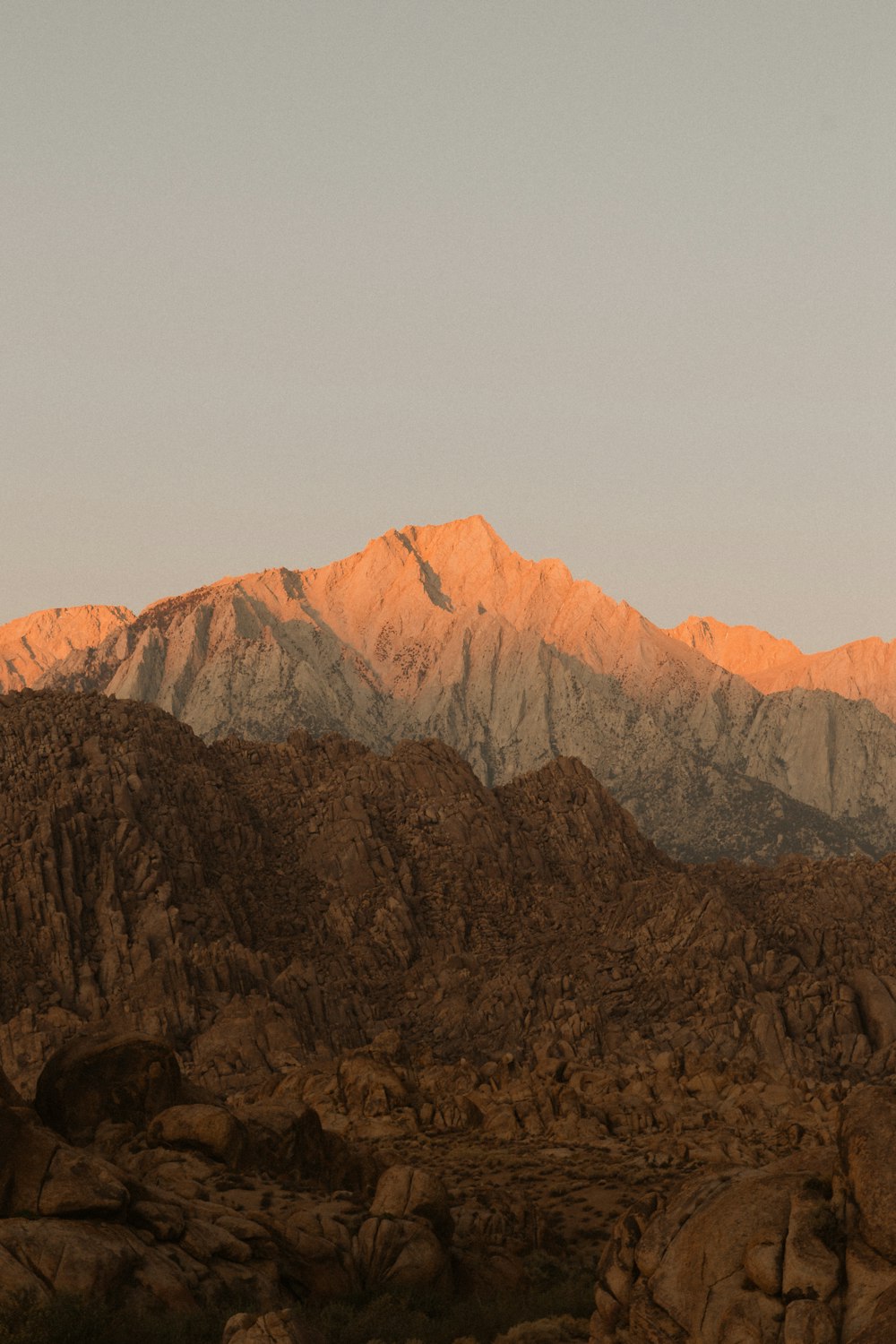 a mountain range with a few rocks in the foreground