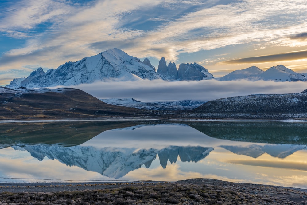 a mountain range with a lake in the foreground