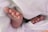 A close-up of tiny baby feet peeking out from soft, white fabric, creating a sense of warmth and tenderness.