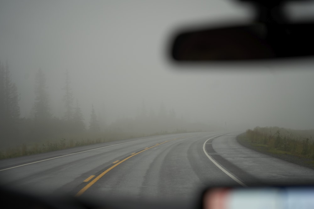 a foggy road in the middle of a forest