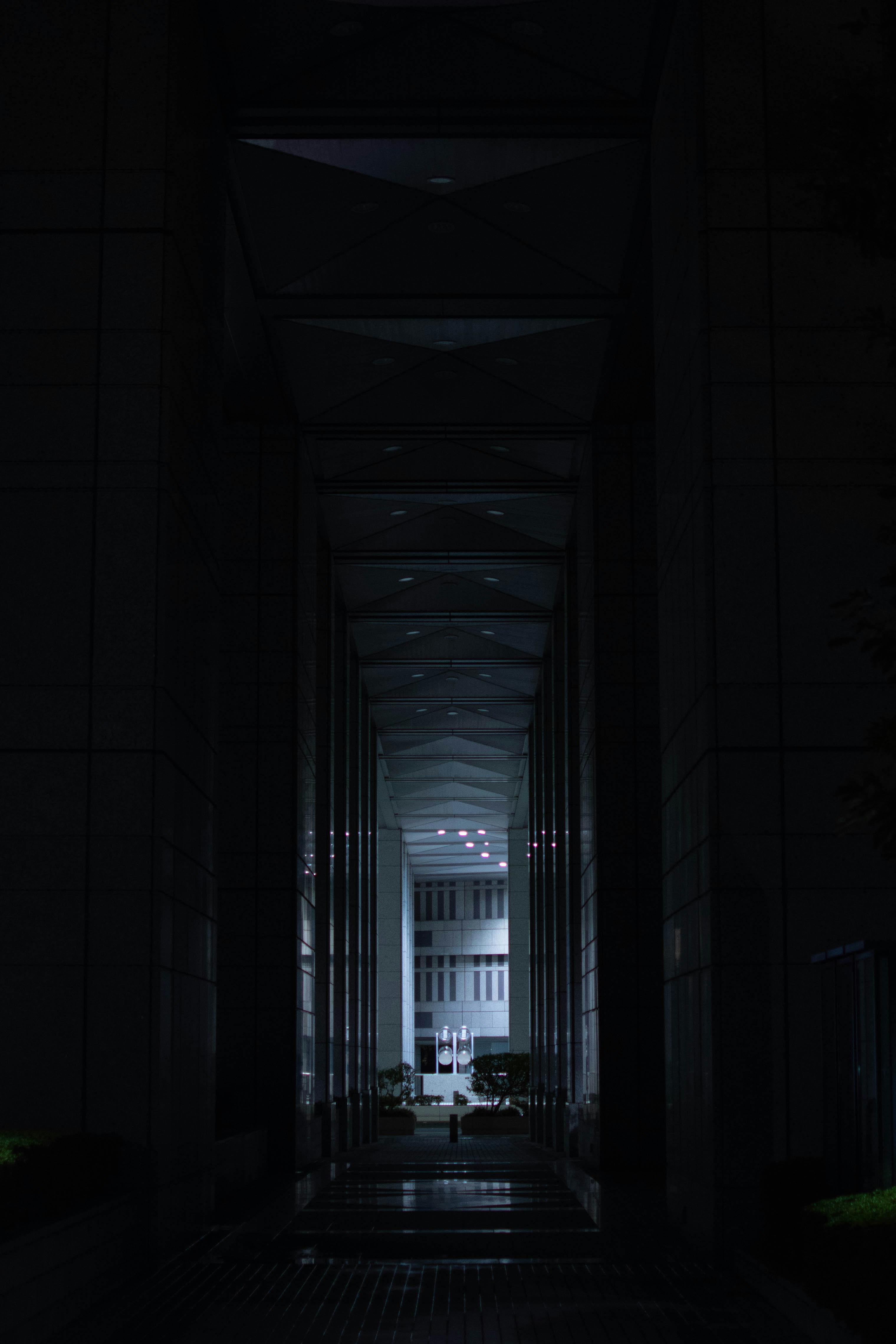 a dark hallway leading to a large building