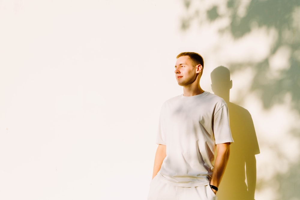 a man standing in front of a white wall