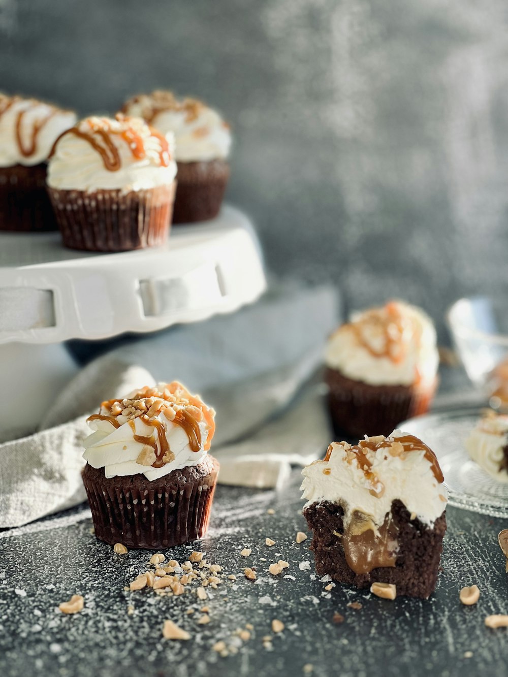 several cupcakes with white frosting and caramel drizzle on top