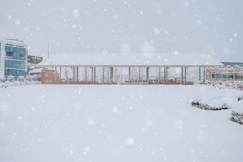 a snow covered field with a building in the background