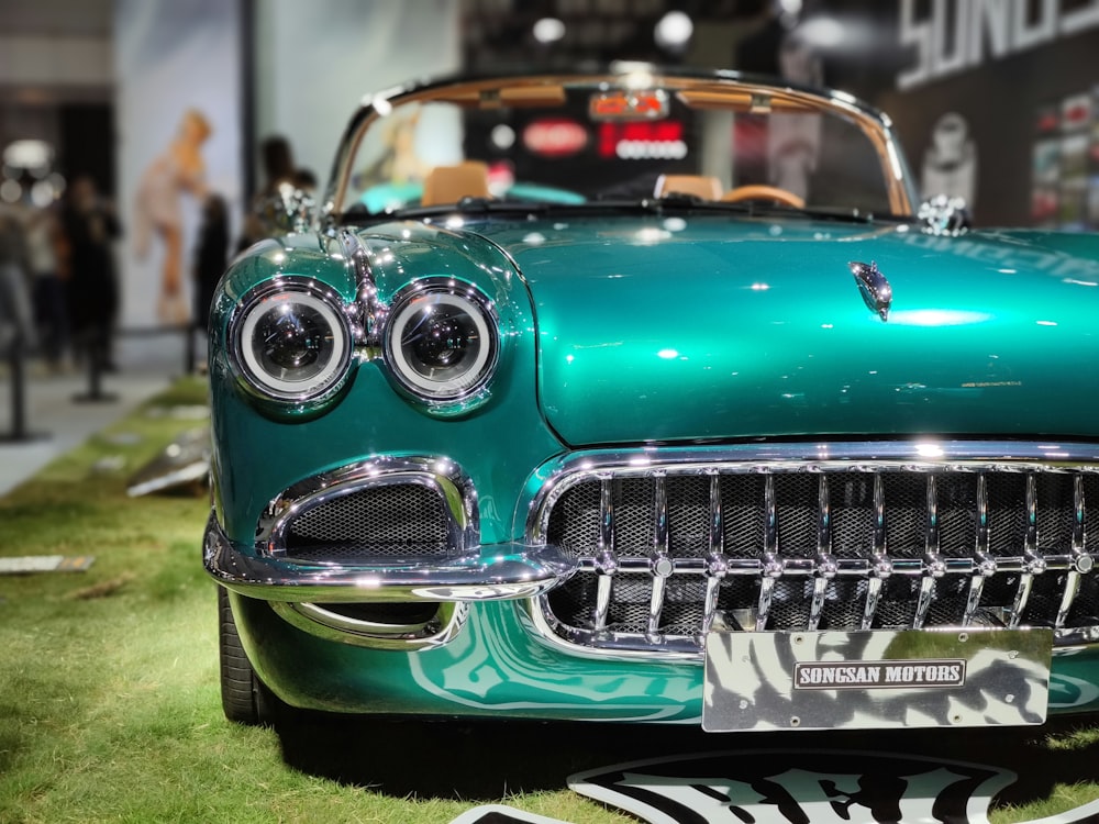 Un'auto d'epoca verde in mostra in un salone dell'auto