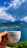 Close-up of a woman enjoying a cup of premium coffee while wearing a brisaviva t-shirt near the ocean.