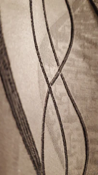 Close-up of charcoal textured layout with subtle gold lines.