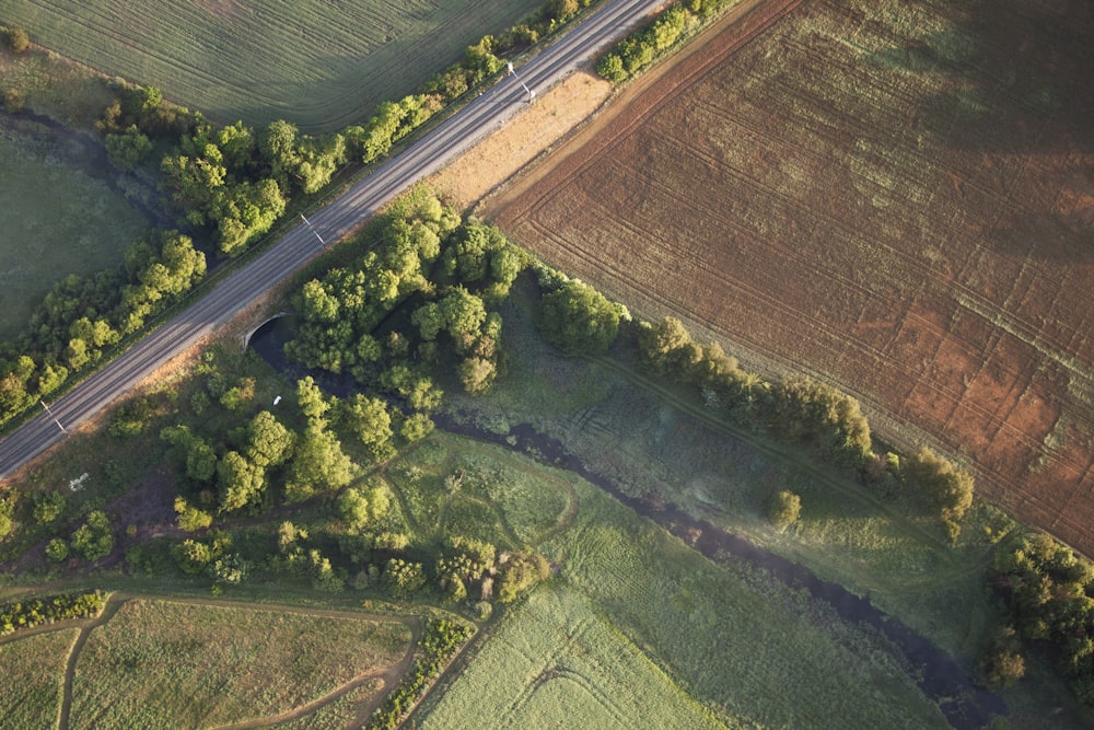 an aerial view of a road in the middle of a field